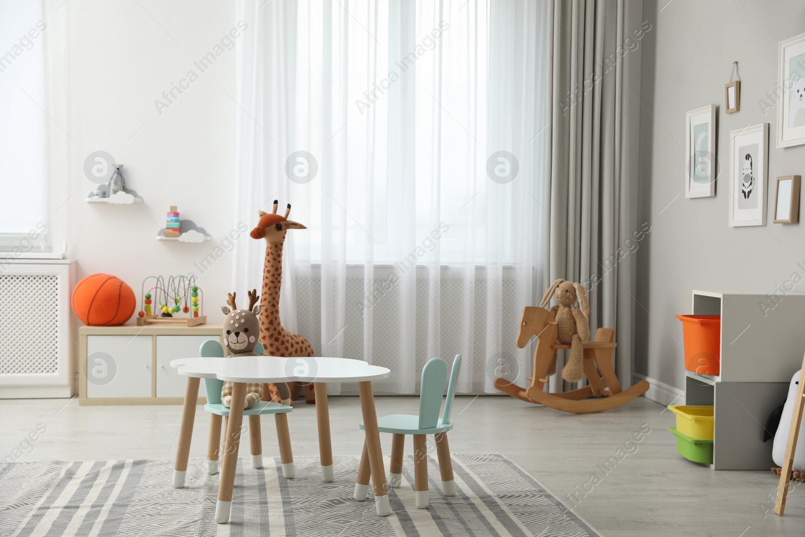 Photo of Child's room interior with stylish table, chairs and toys