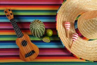 Photo of Flat lay composition with Mexican sombrero hat and ukulele on color table