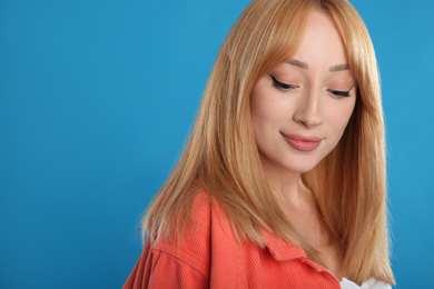 Photo of Beautiful young woman with blonde hair on blue background