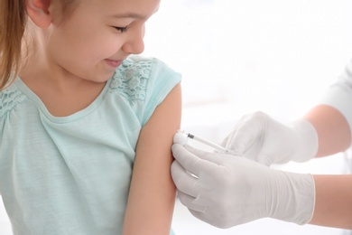 Doctor vaccinating little girl in hospital