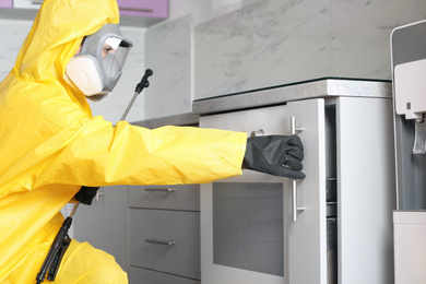 Pest control worker opening drawer in kitchen