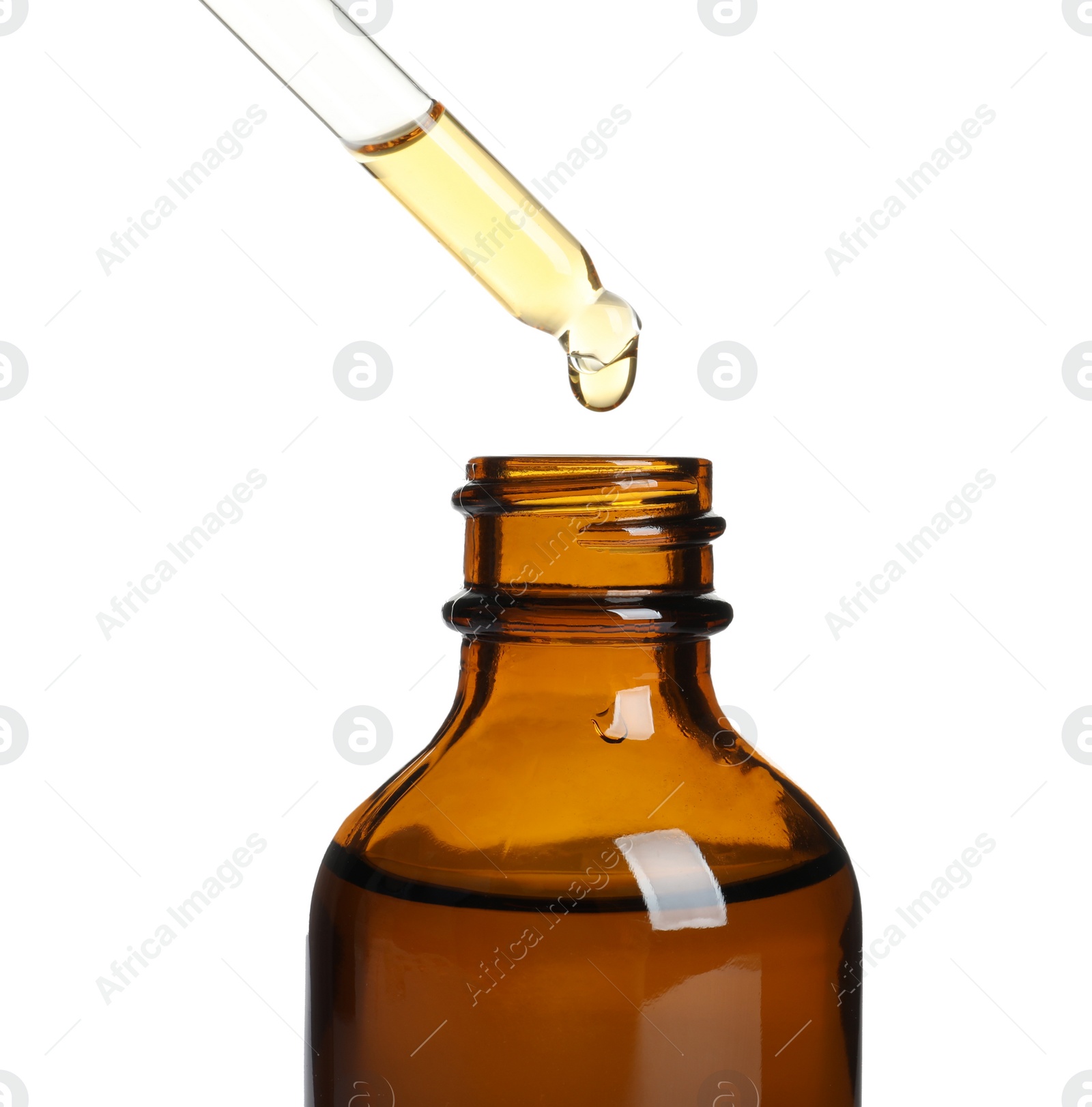 Photo of Dripping natural tea tree essential oil into bottle on white background
