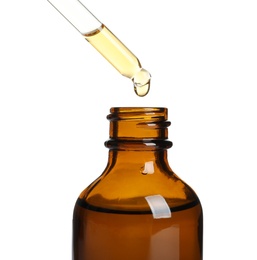 Photo of Dripping natural tea tree essential oil into bottle on white background