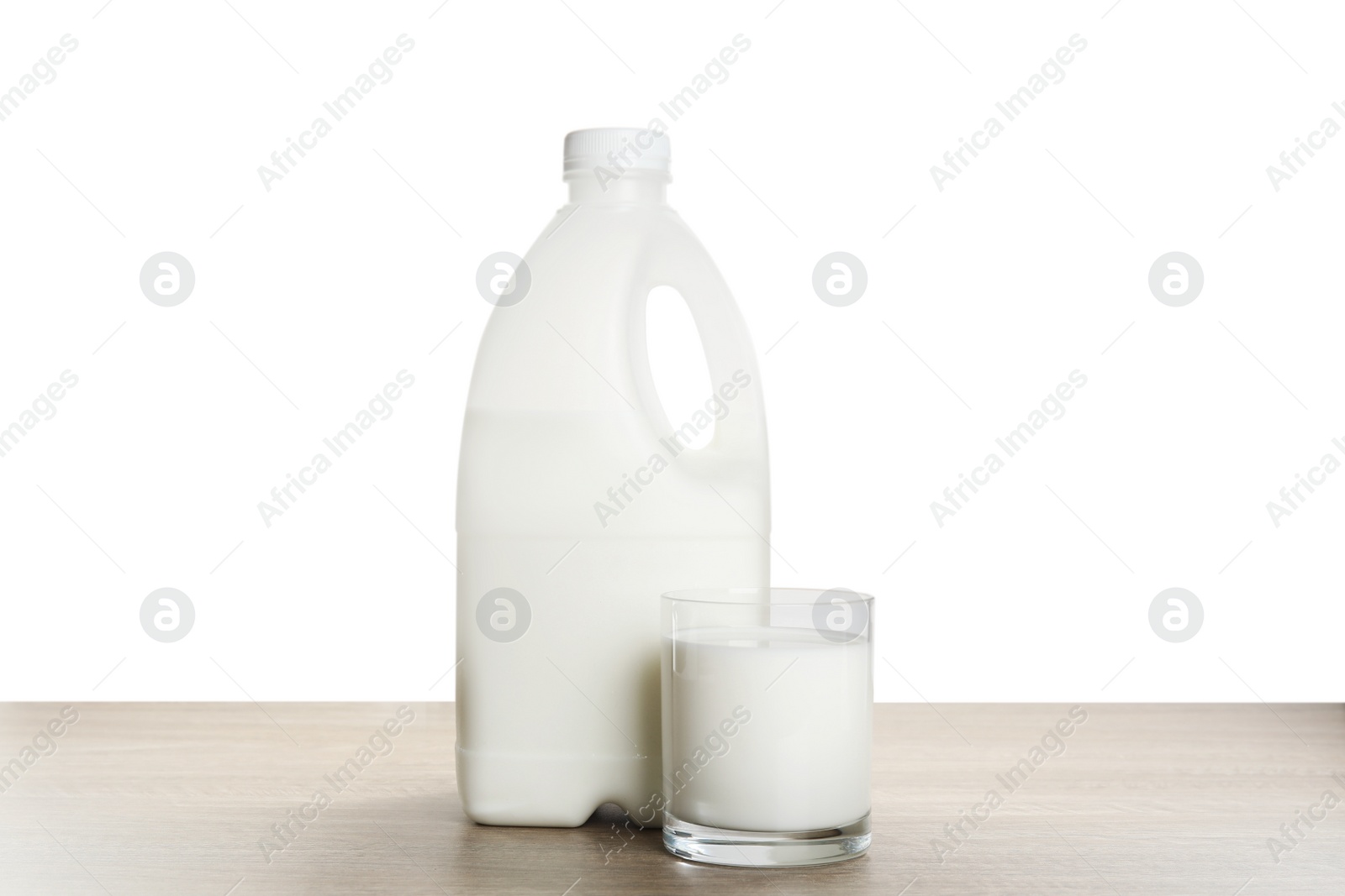 Photo of Gallon bottle and glass of milk on wooden table