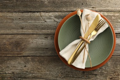 Photo of Stylish setting with cutlery, bowl and plate on wooden table, top view. Space for text