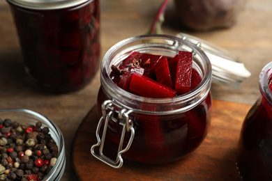 Photo of Delicious pickled beets and spices on wooden table, closeup