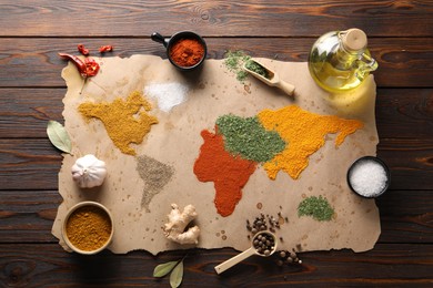 Photo of World map of different spices and products on wooden table, top view