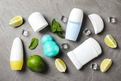 Photo of Flat lay composition with female roll-on deodorants on grey table