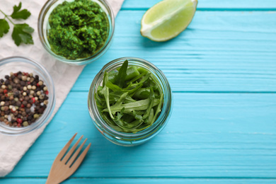 Flat lay composition with jar of fresh greens on light blue wooden background