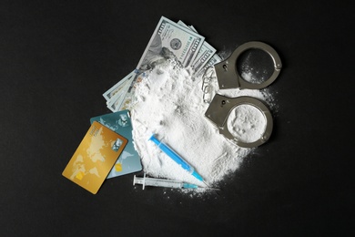 Photo of Composition with heap of cocaine and syringes on black background, top view