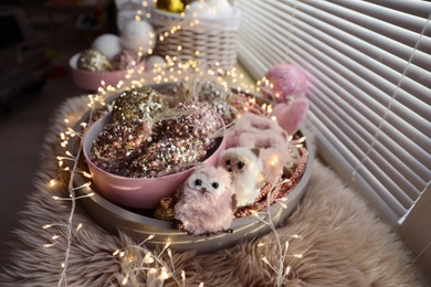 Photo of Beautiful Christmas tree baubles, toys and fairy lights on window sill indoors