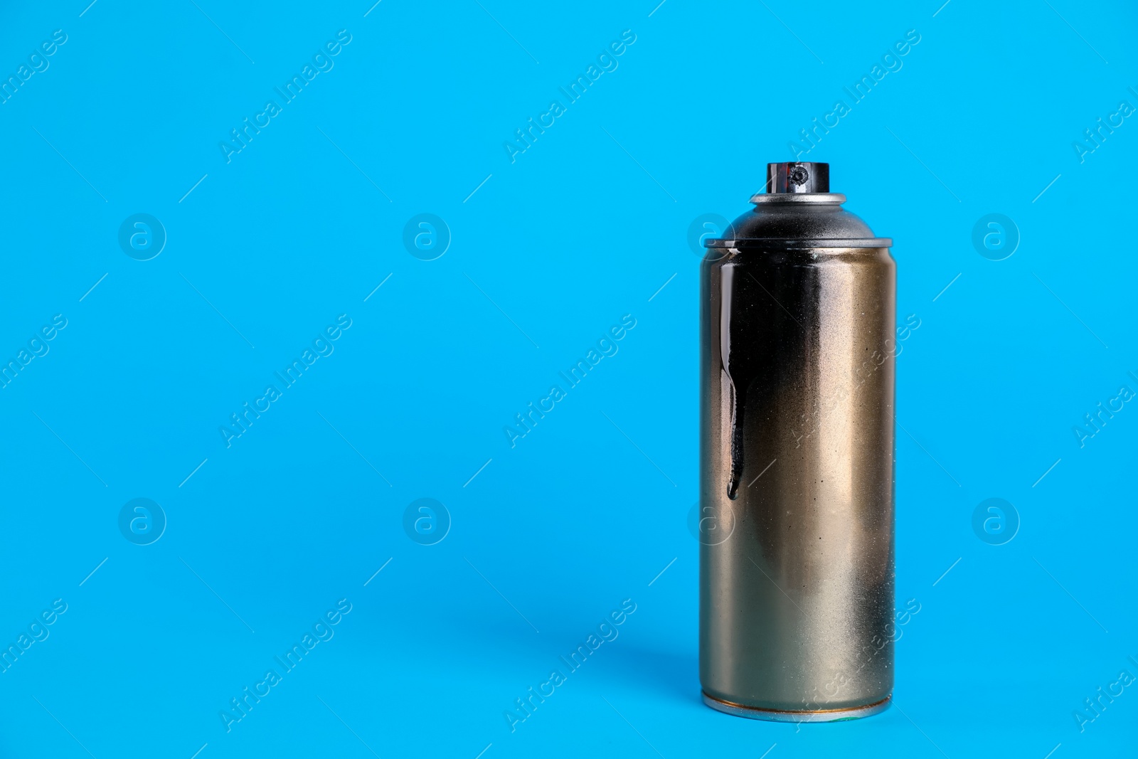 Photo of Used can of spray paint on light blue background. Space for text