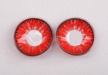 Photo of Two red contact lenses on white background, top view