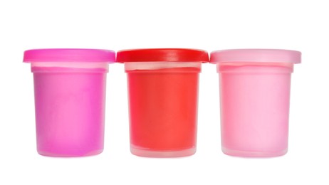 Photo of Plastic containers with different color play dough isolated on white
