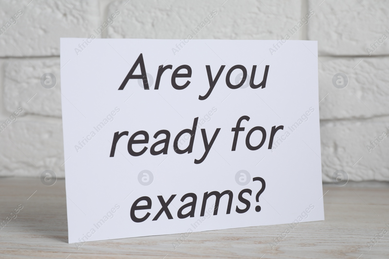 Photo of Paper with question Are you ready for exams on white wooden table, closeup