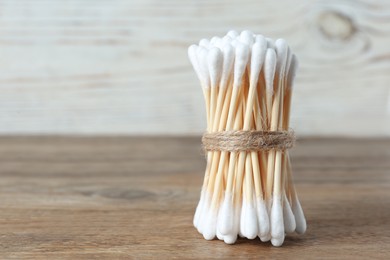 Photo of Many cotton buds on wooden table, space for text