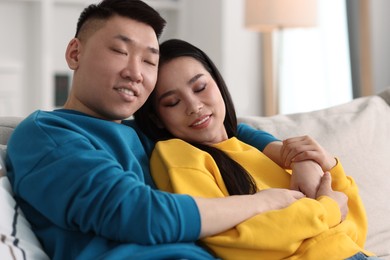 Photo of Happy young couple on sofa at home