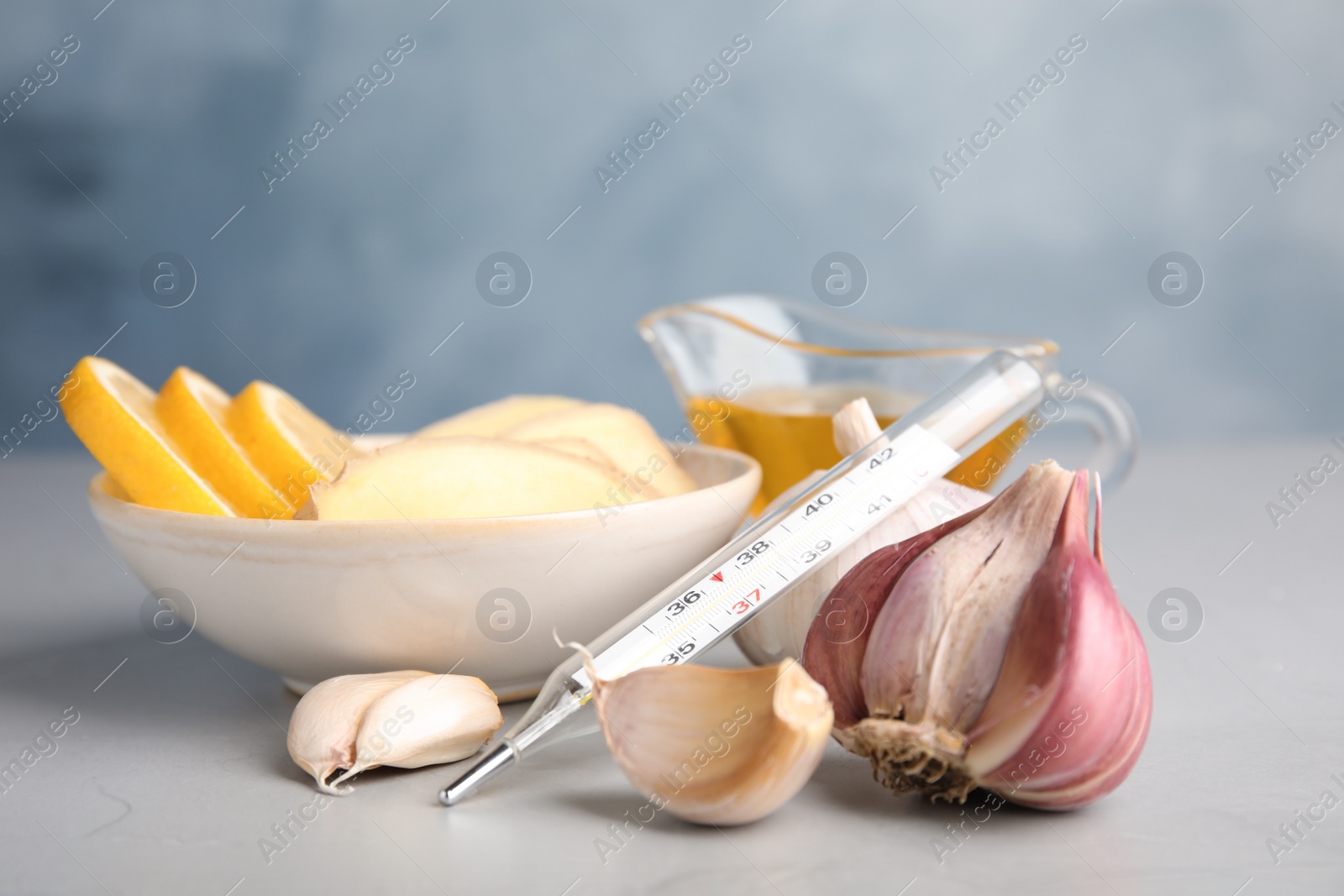 Photo of Composition with garlic and other cold remedies on grey table