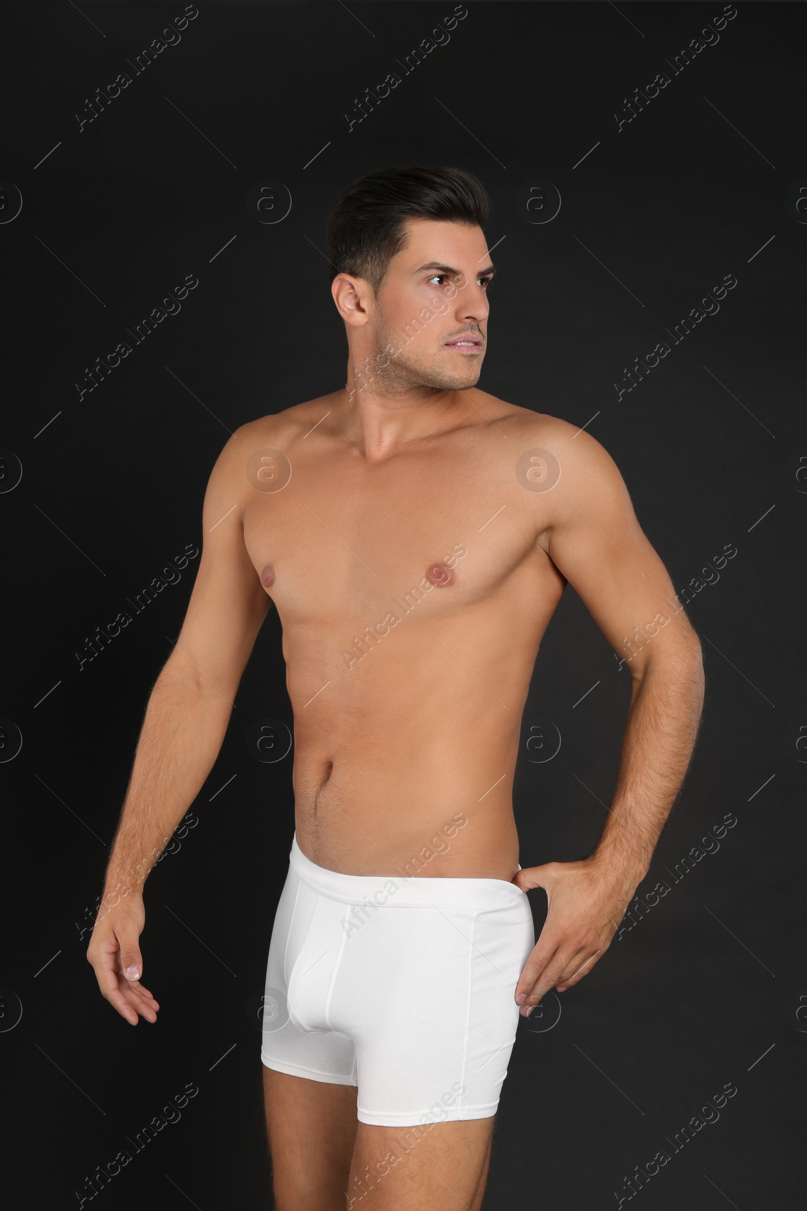 Photo of Handsome man in underwear on black background