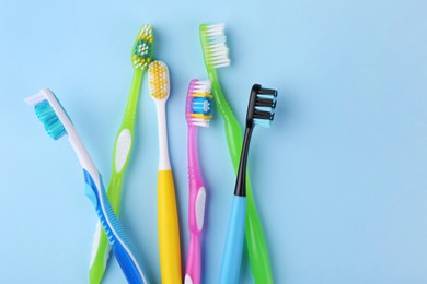 Photo of Many different toothbrushes on light blue background, flat lay. Space for text