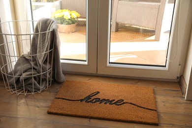 Photo of Doormat with word Home on parquet floor indoors