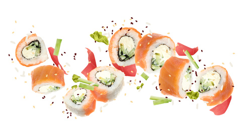 Delicious sushi rolls and ingredients on white background