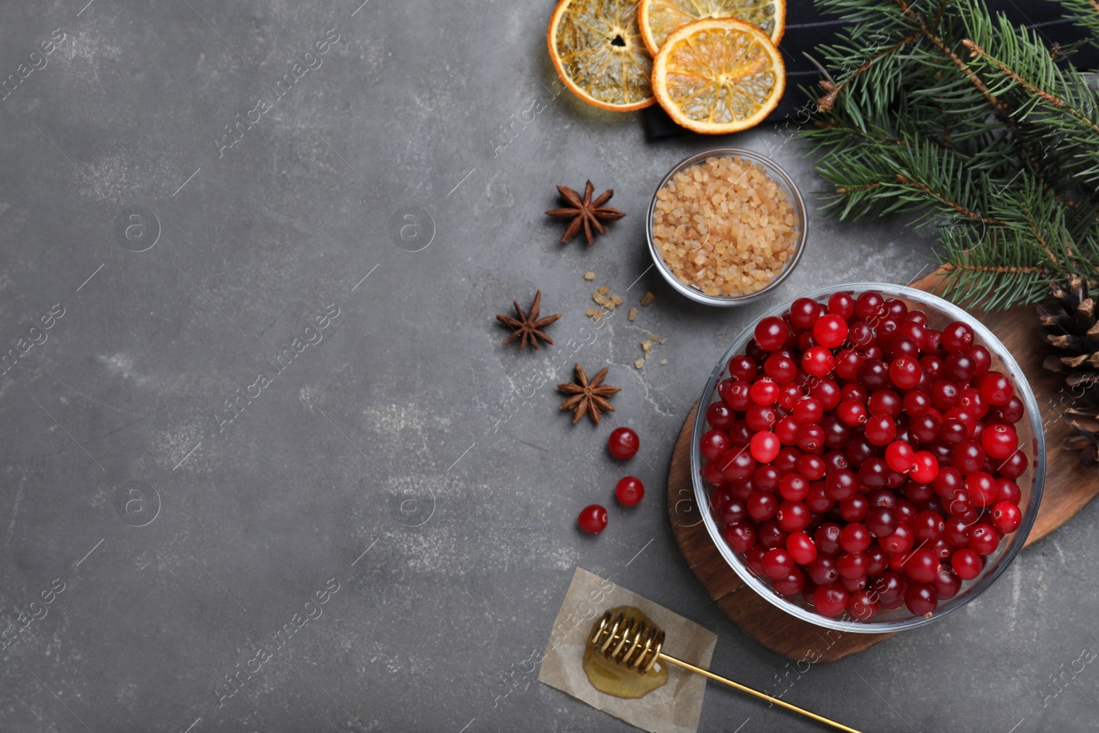 Photo of Flat lay composition with fresh ripe cranberries on grey table. Space for text
