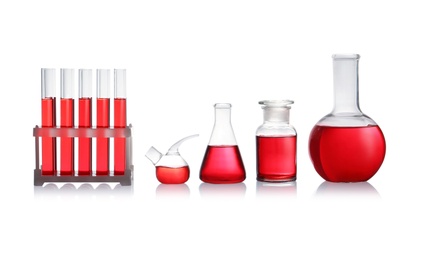 Set of laboratory glassware with red liquid on white background