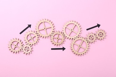 Photo of Business process organization and optimization. Scheme with wooden figures and arrows on pink background, top view