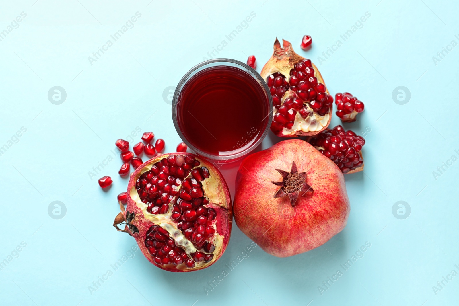 Photo of Glass of pomegranate juice and fresh fruits on color background, top view