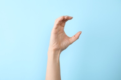 Photo of Woman showing C letter on color background, closeup. Sign language