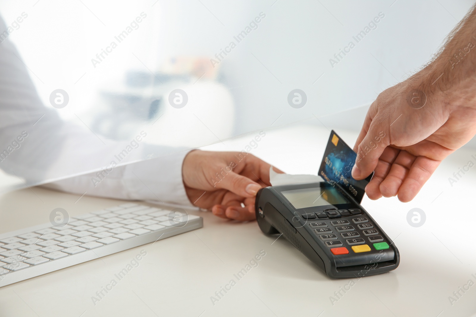 Photo of Man using bank terminal for credit card payment at cash department window, closeup