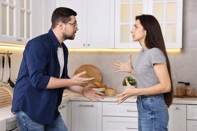 Photo of Emotional couple arguing in kitchen. Relationship problems