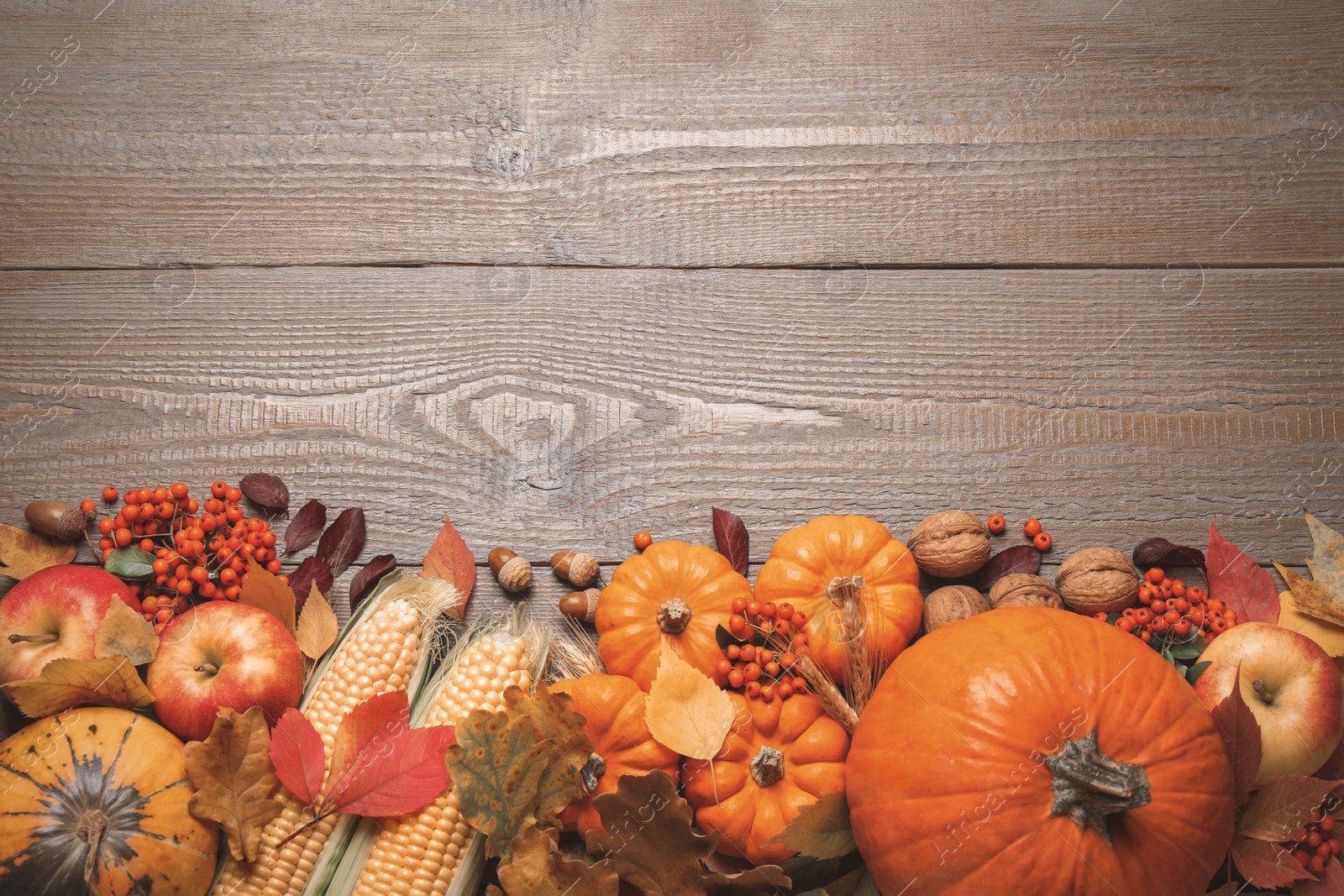 Photo of Flat lay composition with vegetables, berries and autumn leaves on wooden table, space for text. Thanksgiving Day