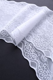 Photo of White lace on black background, closeup view