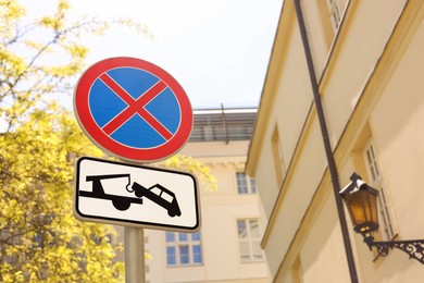 Photo of Post with No stopping road sign and complementary plate outdoors, low angle view. Space for text