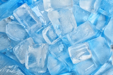 Many ice cubes on color background, top view