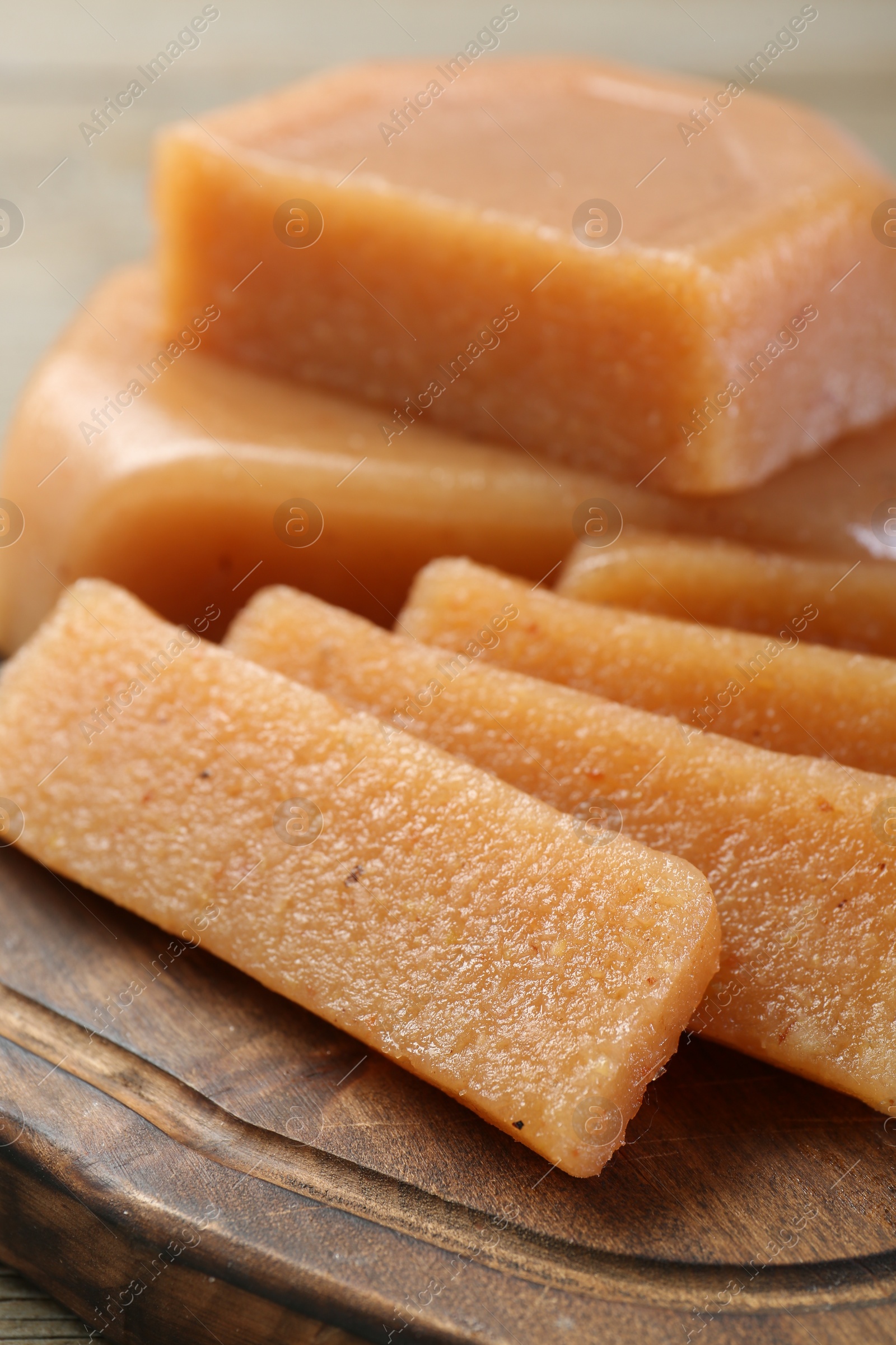 Photo of Tasty sweet quince paste on wooden board, closeup