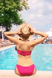 Photo of Young woman near pool on sunny day