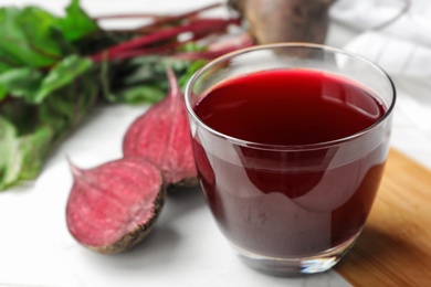 Glass of beet juice on table. Space for text