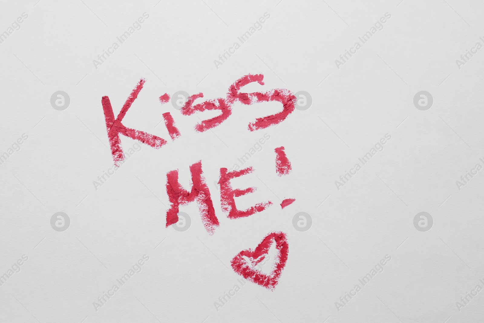 Phrase Kiss Me and red heart made of lipstick on white background Photo of Phrase Kiss Me and red heart made of lipstick on white background