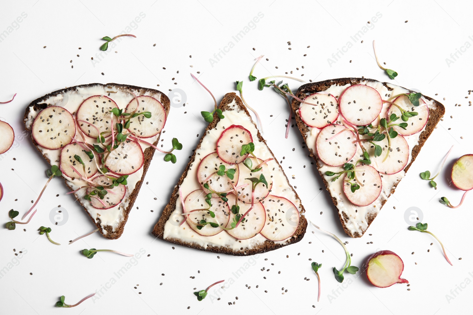 Photo of Tasty toasts with radishes, sprouts and chia seeds on white background, top view