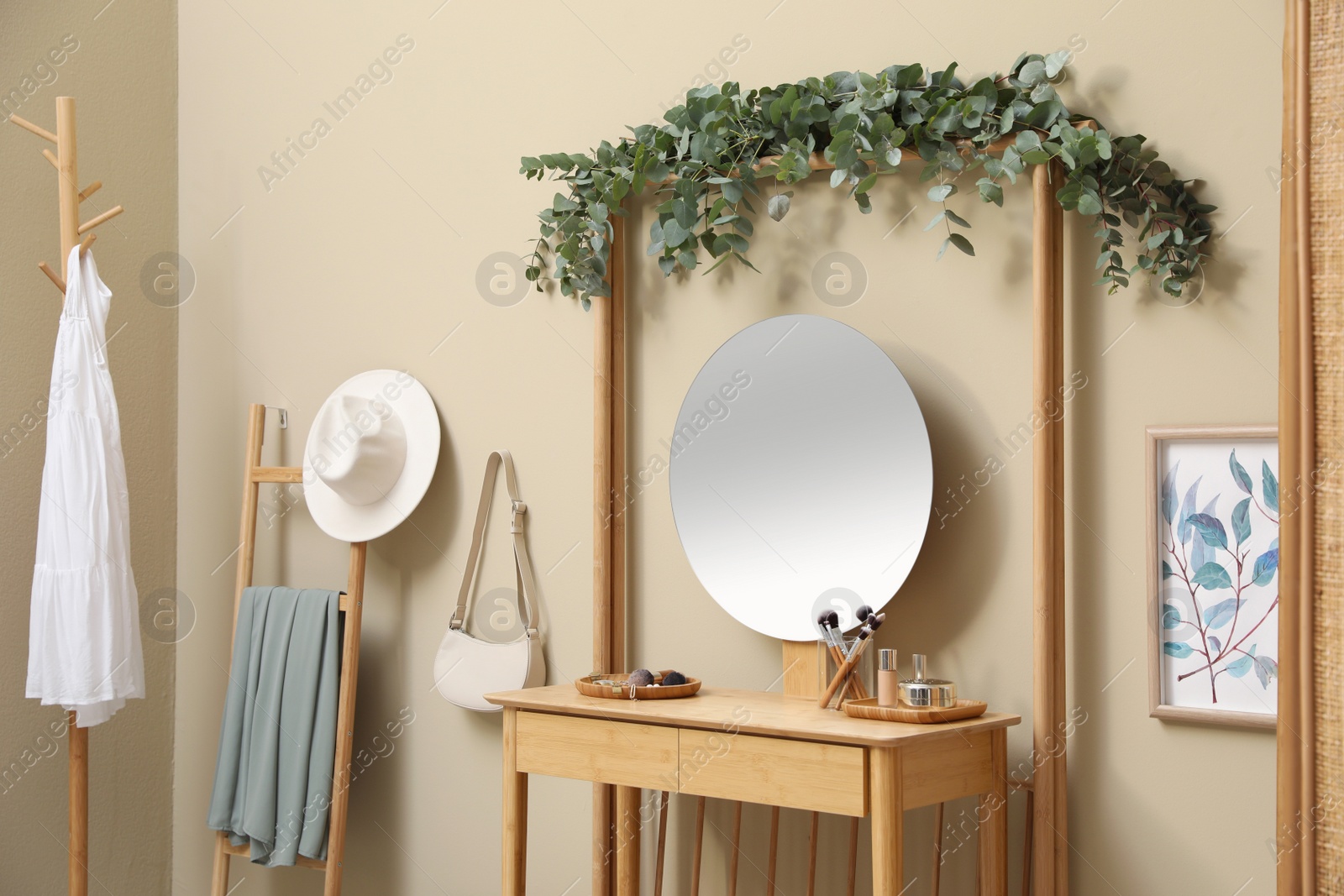 Photo of Stylish room decorated with beautiful eucalyptus garland on dressing table