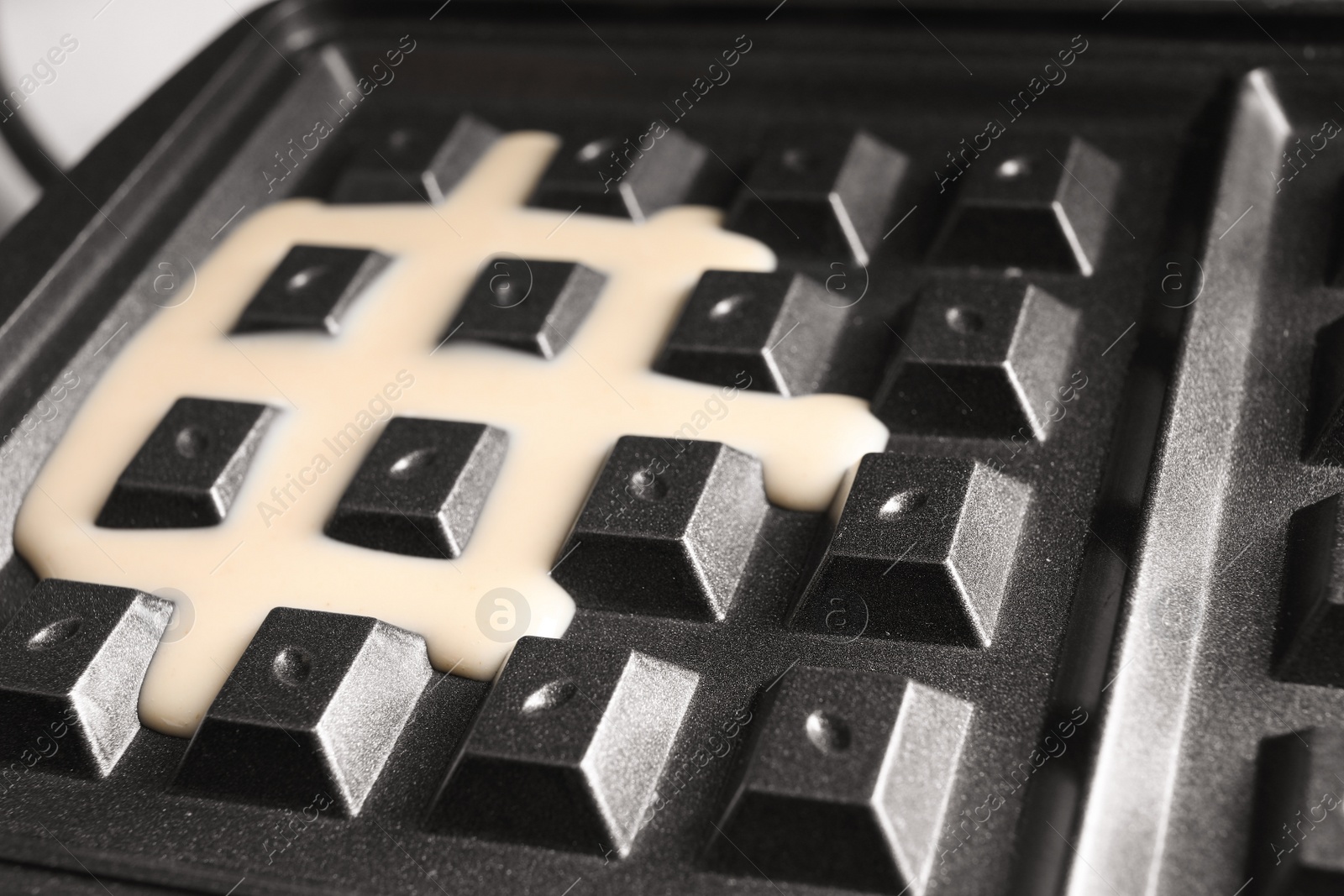 Photo of Modern Belgian waffle maker with dough, closeup