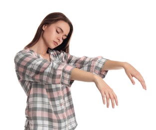 Photo of Young woman wearing pajamas in sleepwalking state on white background