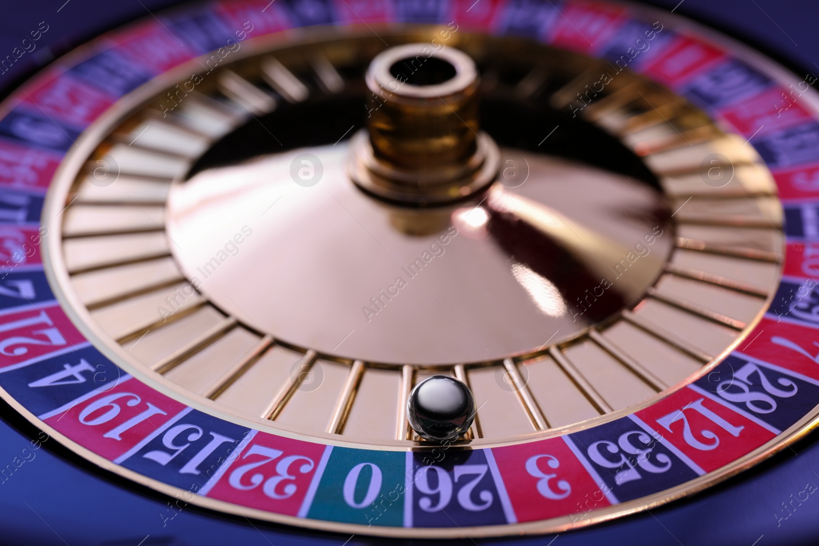 Photo of Roulette wheel with ball, closeup. Casino game