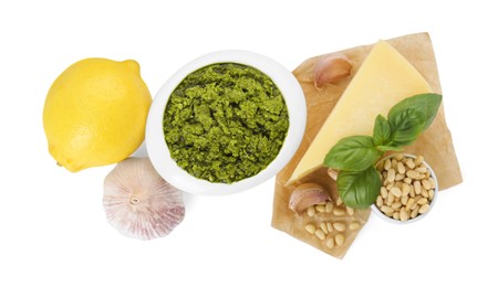 Delicious pesto sauce in bowl and ingredients isolated on white, top view