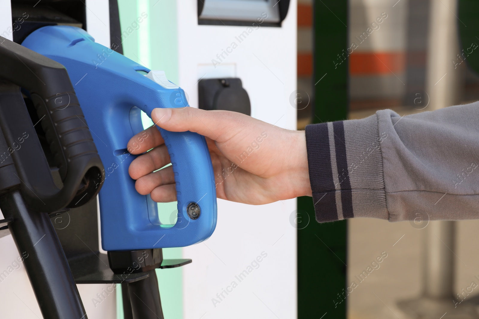 Photo of Man taking power cable supply for electric car charging, closeup