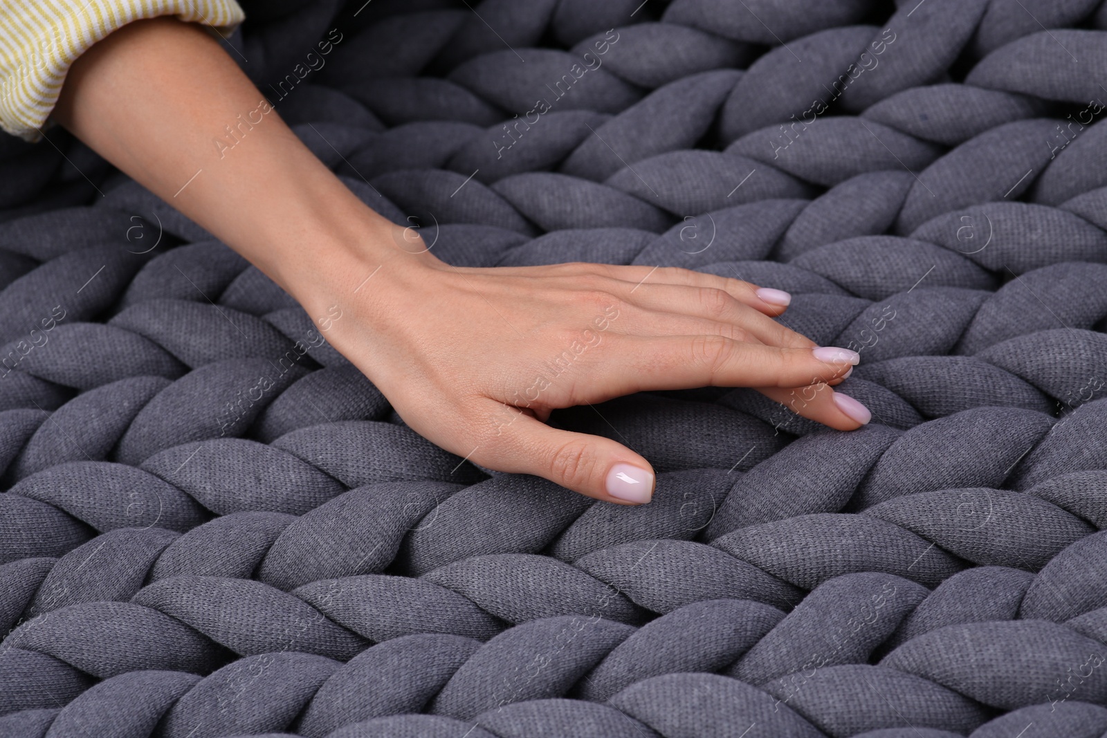 Photo of Woman touching grey chunky knit plaid, closeup