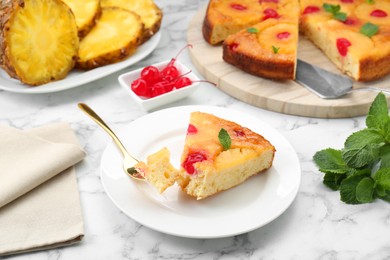 Photo of Eating piece of delicious pineapple pie with cherry and mint on white marble table